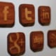 A wall display of wood-carved social media icons.