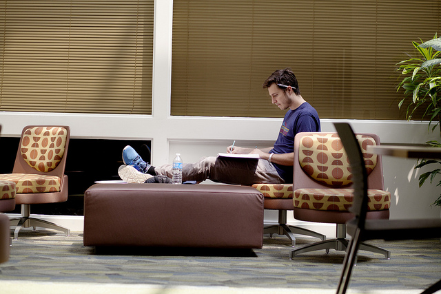 A student studies alone in a lounge.