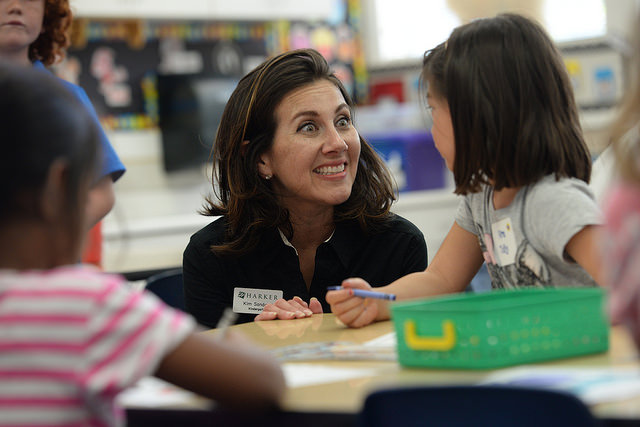 A kindergarten teacher has an excited exchange with their student.