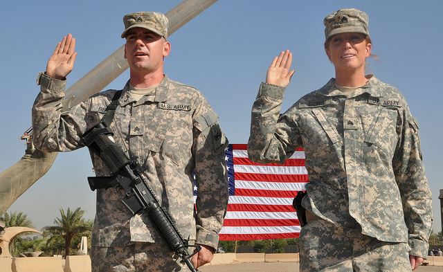 Two soldiers with their right hands raised take the United States Armed Forces Oath of Enlistment.