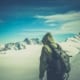 Mountaineer with pack makes a path through snowy peaks