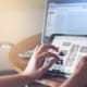 Person working on both a laptop and a tablet, keyboard and touchscreen