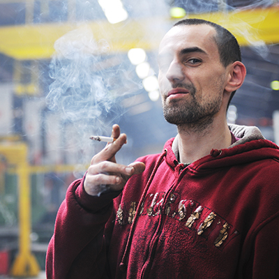 Man smoking cigarette after completing a fraudulent return.