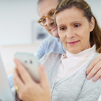 A senior couple using their iPhone to take advantage of an exclusive offer with SheerID's Digital Verification Platform.