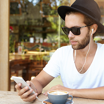 College student listening to streaming music service he purchased with a student discount.