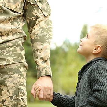 A military man hold his son's hand. Kettlebell Kitchen uses gated offers to deliver a 15% discount to members of the military.