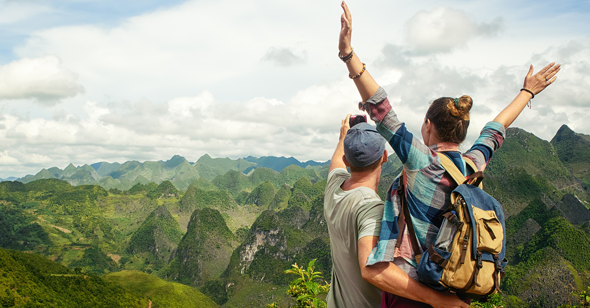A young couple on a mountain vacation they redeemed through a travel customer loyalty program.