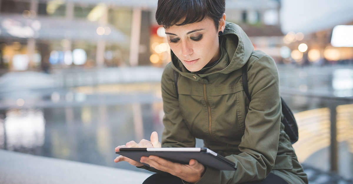 A digital marketer researching customer acquisition trends and tips on her tablet.