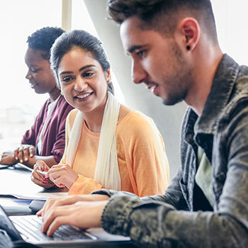 Students in a computer lab using free software Alteryx provided to grow customer loyalty.