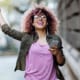 Young woman with pink hair streams her music with Spotify's gated, exclusive offer for students.