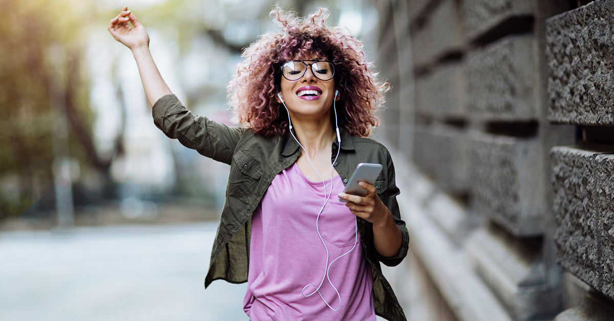 Young woman with pink hair streams her music with Spotify's gated, exclusive offer for students.