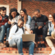 A group of Gen Zers gathered around a laptop to redeem a student discount using worldwide student verification.