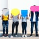 College students standing in a line covering their faces with cut outs of chat bubbles.