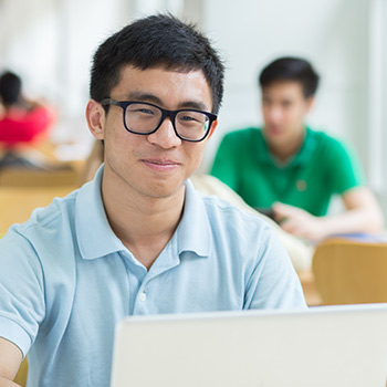 An Asian student smiling after using student verification to redeem a student discount.