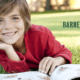 A young student reading a book his teacher purchased with a discount that used teacher verification.