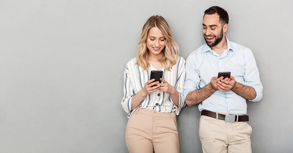 A man and woman verifying a personalized offer on their cell phones, underscoring the importance of customer verification for brands.