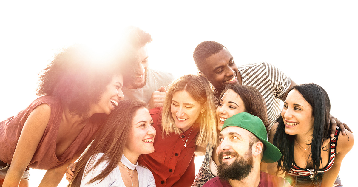 A huddle of smiling college students brands can target with personalized marketing.