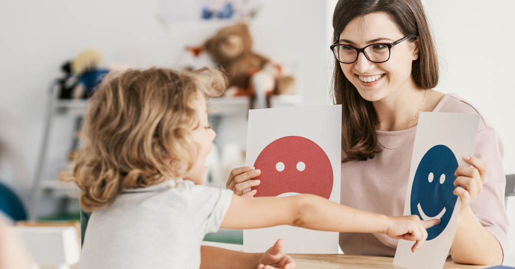 A female teacher uses a game she purchased with a personalized promotion to instruct a young girl.