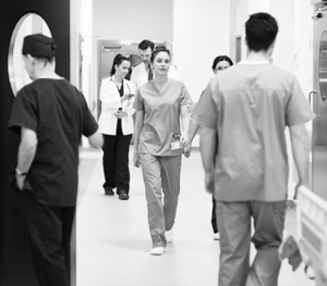Nurses and doctors walking in a hospital hallway.