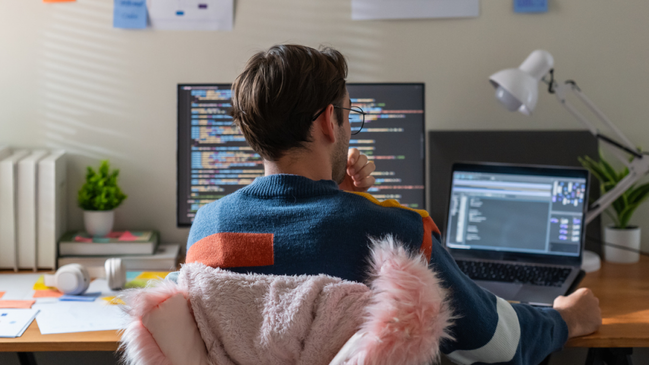 Software developer working on two screens.