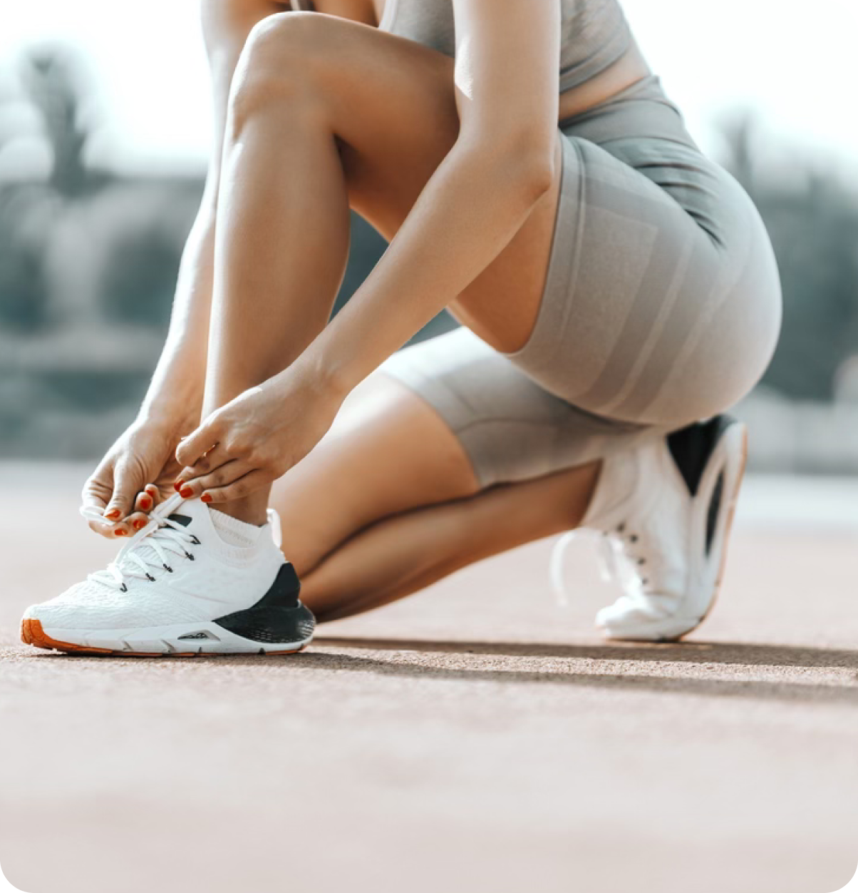 Woman ties shoes at track.