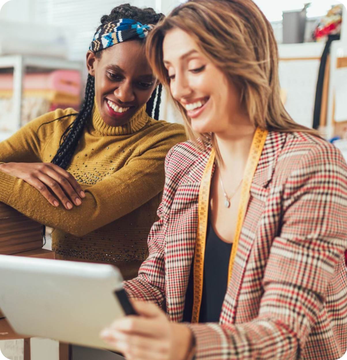 Store clerk and shopper smiling at tablet.