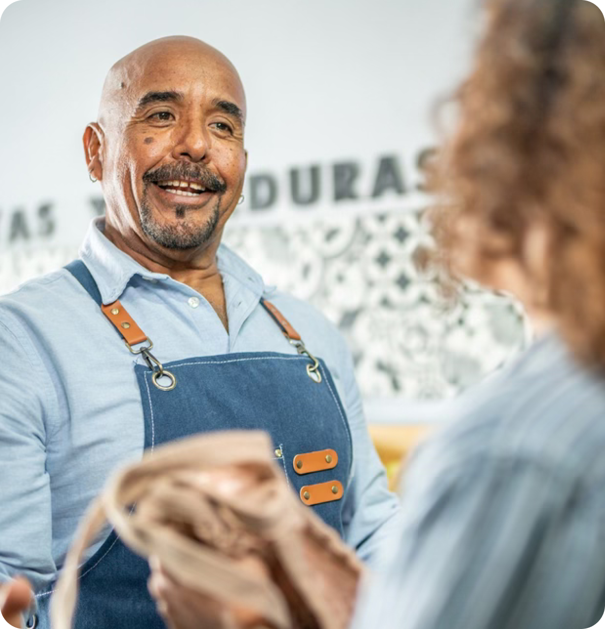 Shop merchant smiles at customer.