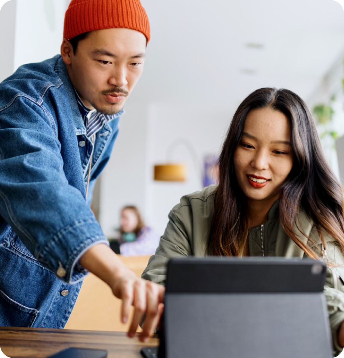 Man points to woman's laptop screen.