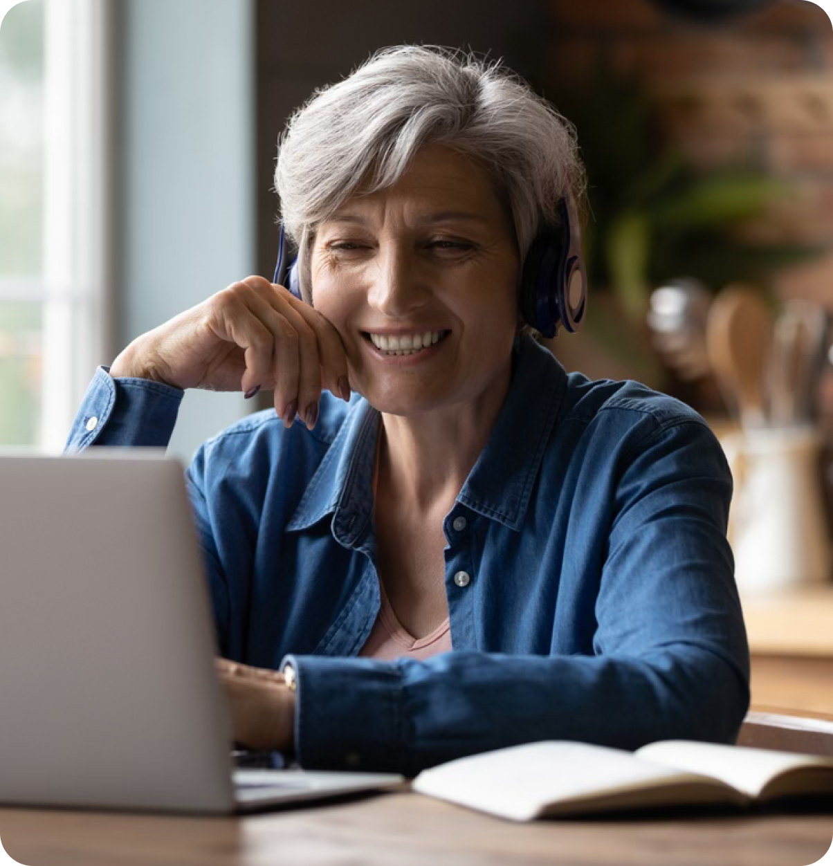 Smiling older adult woman at laptop.