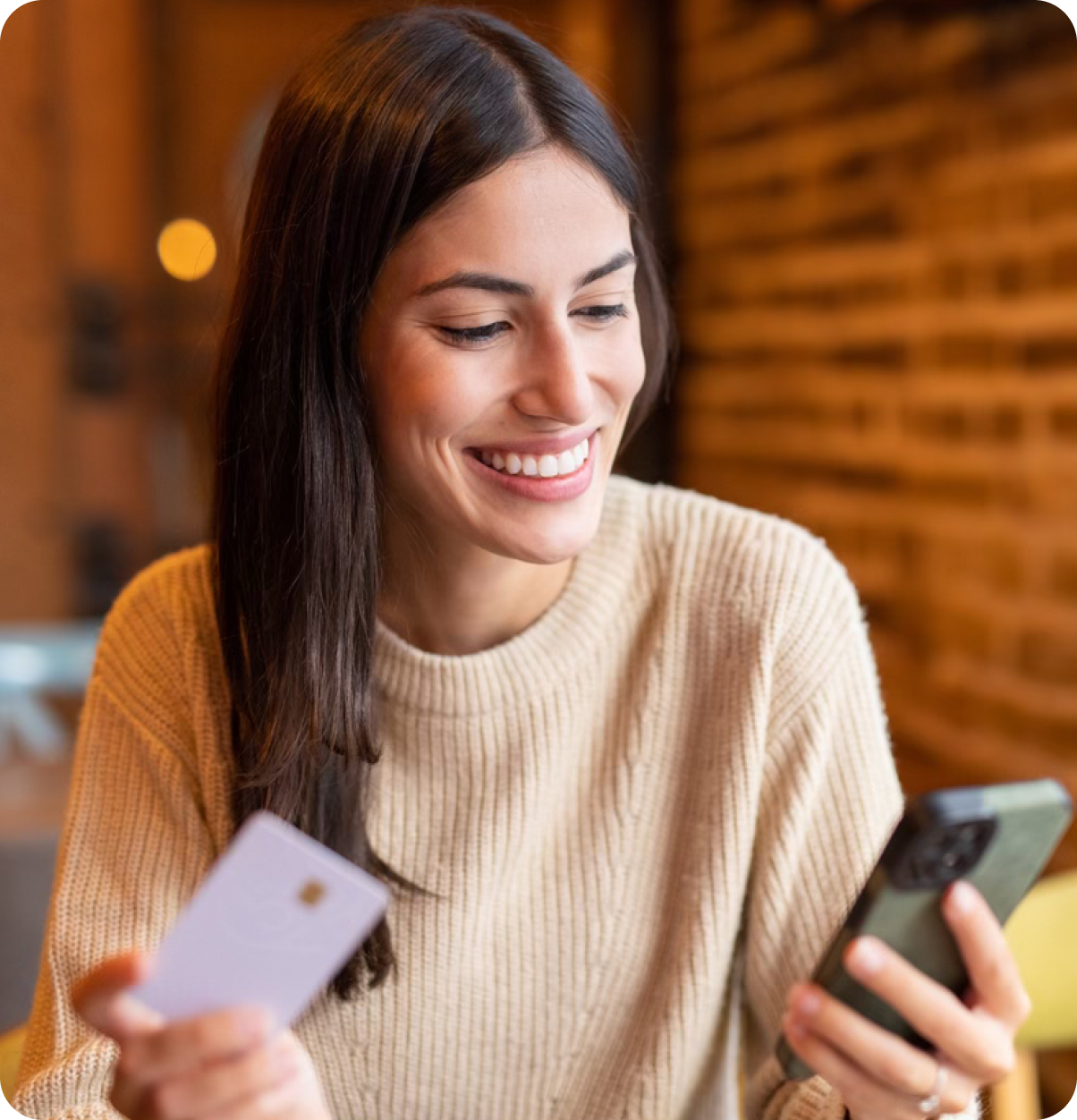 Smiling woman making transaction on phone.