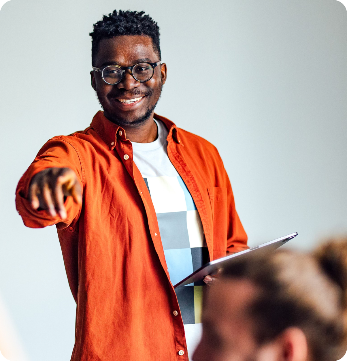 Teacher holding tablet calling on a student.