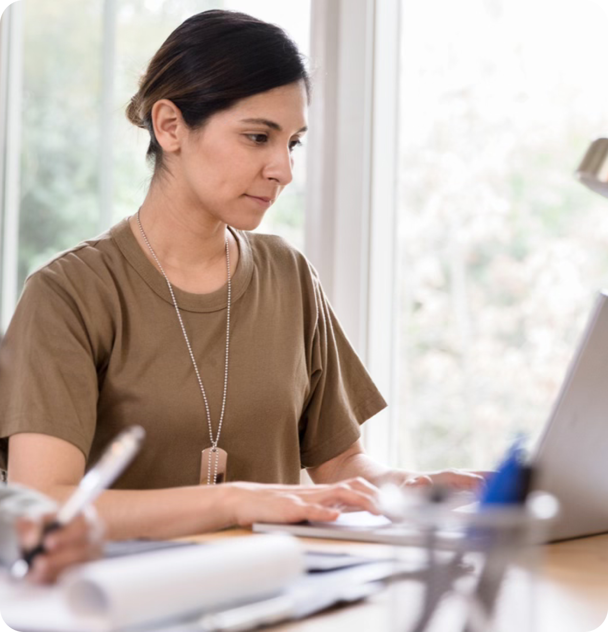 Female military member uses laptop.