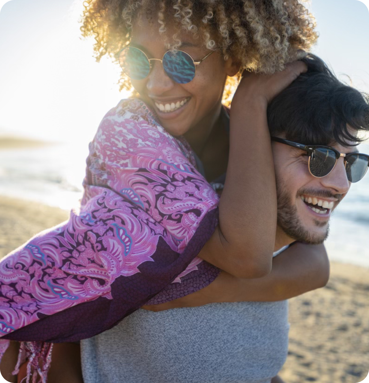 Young couple smiling at the beach.