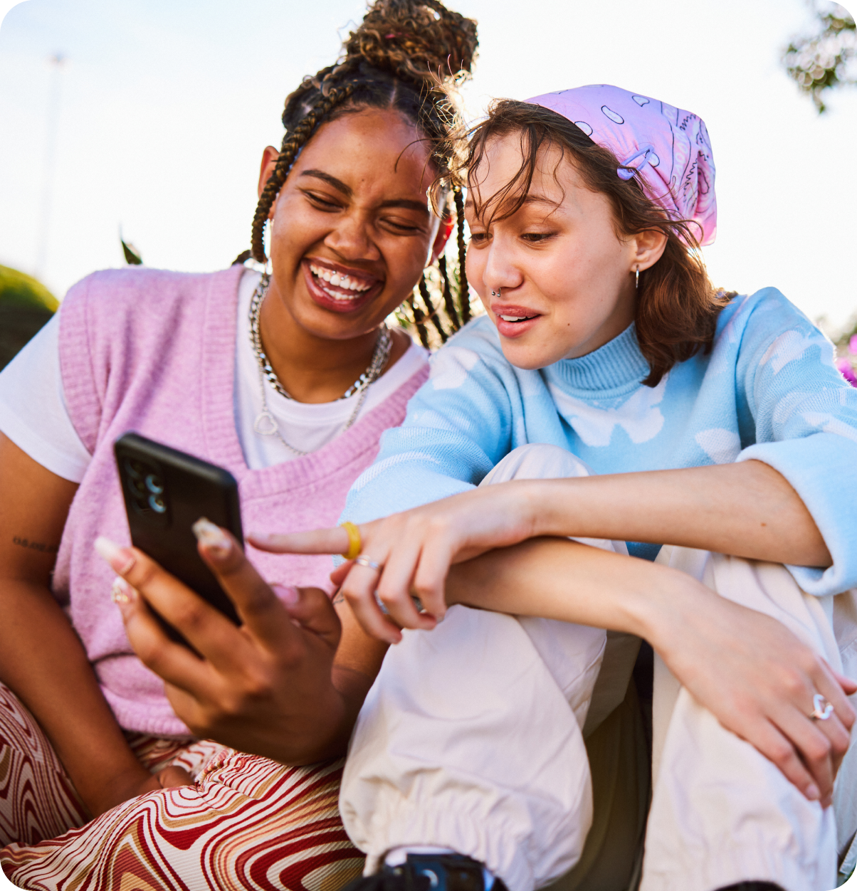 Two friends point at phone screen.