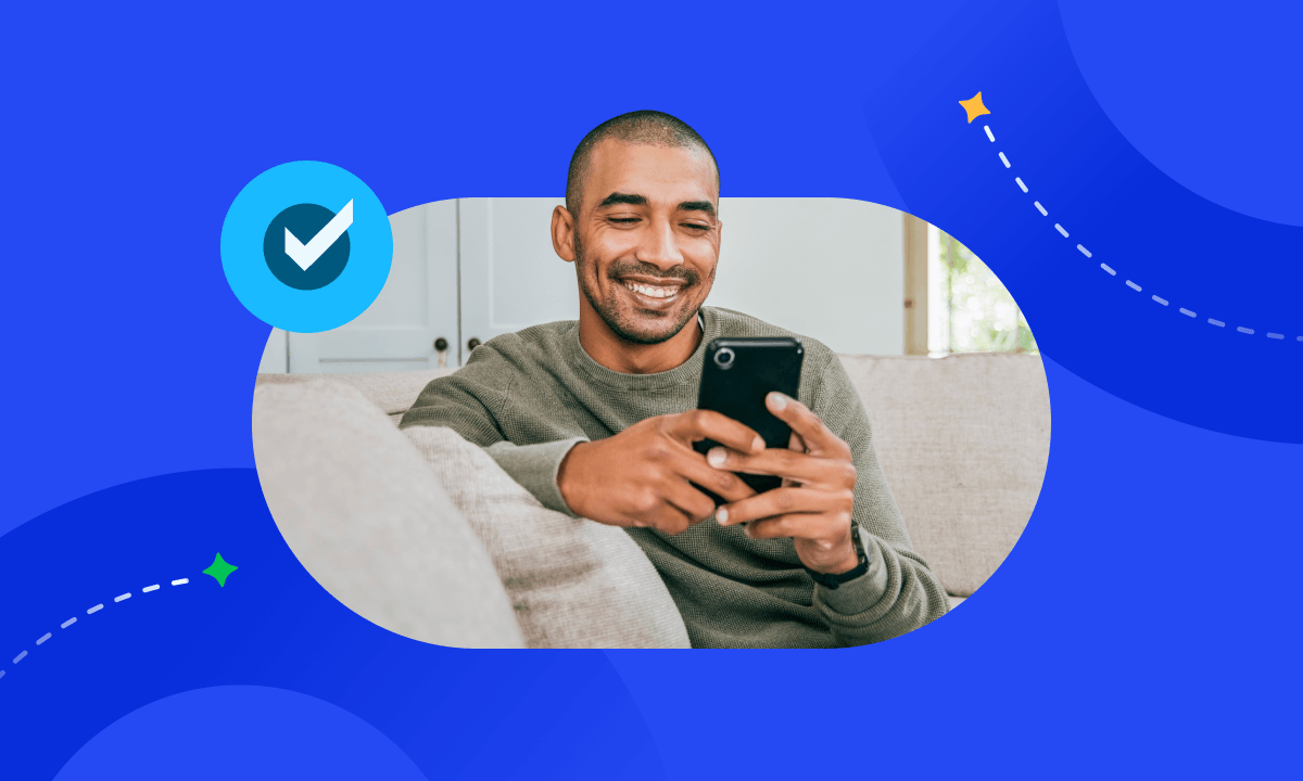 A man smiling while holding a phone, accented by a blue checkmark icon signifying successful verification.